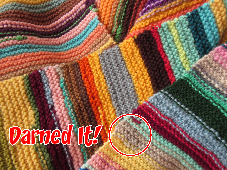 close up of scarf with darned area circled